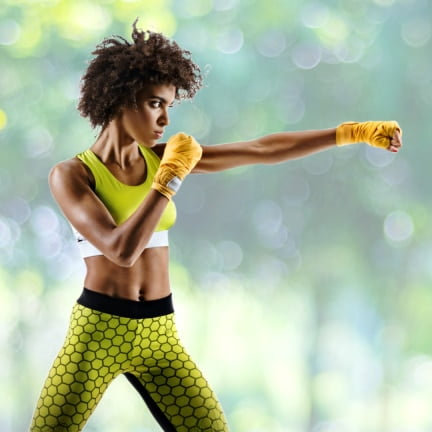 a woman in a yellow sports bra top and yellow gloves.