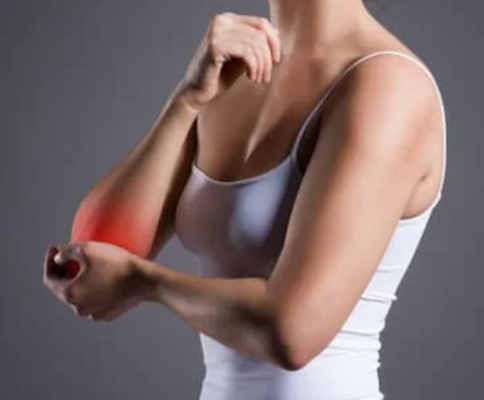 a woman holding her arm in pain.